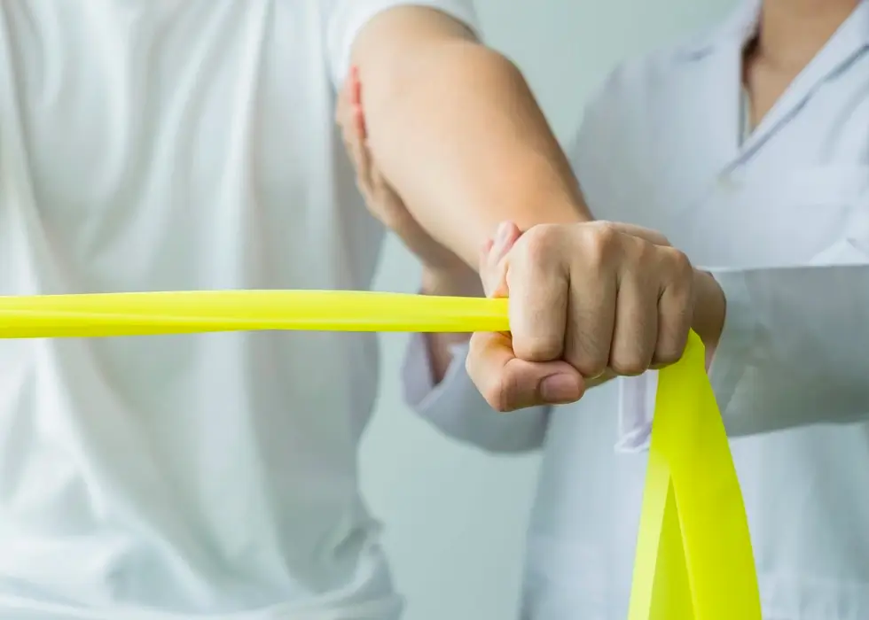 Patient mit Gymnastik-Stretchband – gezielte Dehn- und Kräftigungsübungen zur Unterstützung der Mobilität und Rehabilitation.