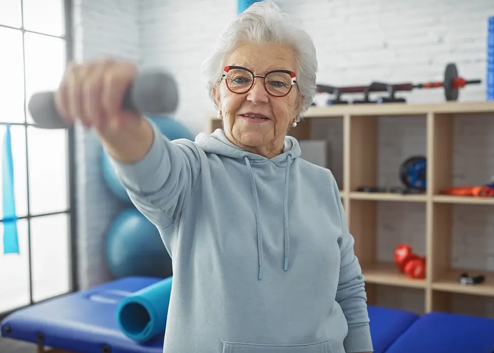 Senior bei der Krankengymnastik mit einer Hantel in der Hand – gezieltes Training zur Förderung von Kraft, Beweglichkeit und Alltagsmobilität.
