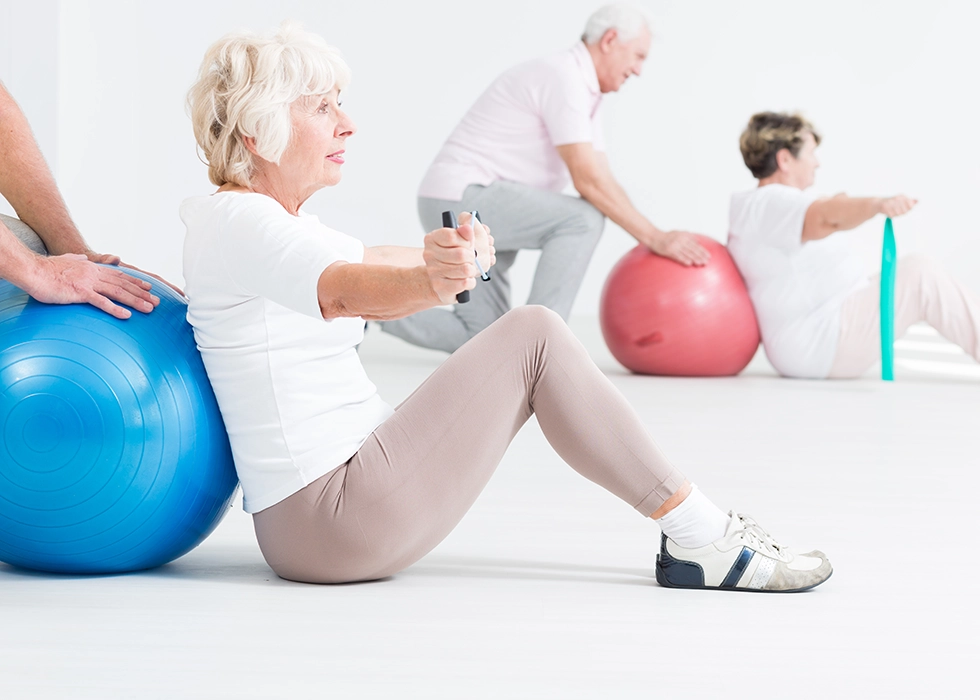 Senioren bei der Krankengymnastik mit Gymnastikball – gezielte Übungen zur Verbesserung von Mobilität, Balance und Muskelkraft in der physiotherapeutischen Praxis.